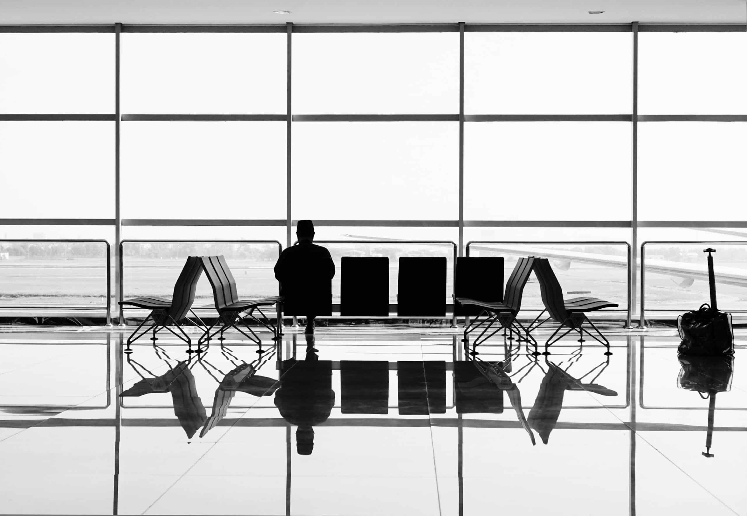 Mann sitzt alleine am Flughafen