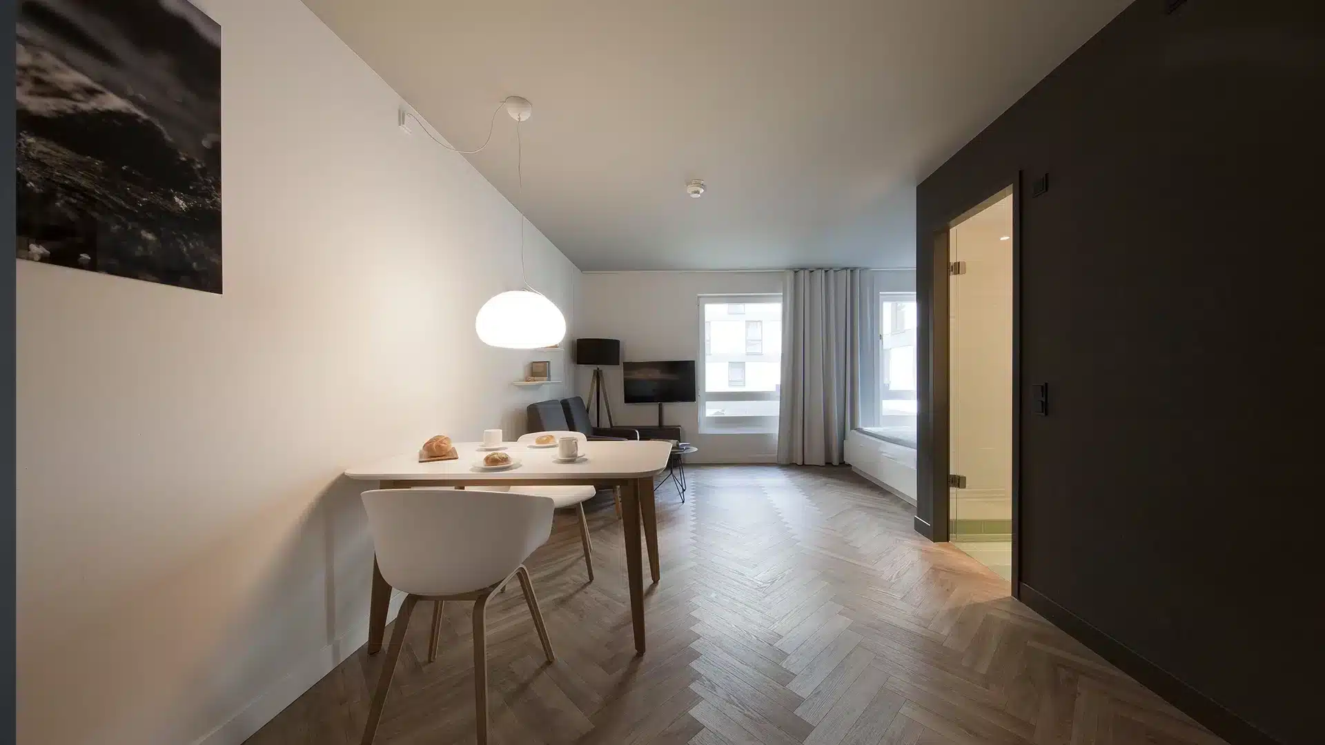 Esstisch und Fenster mit Vorhängen in heller Wohnung