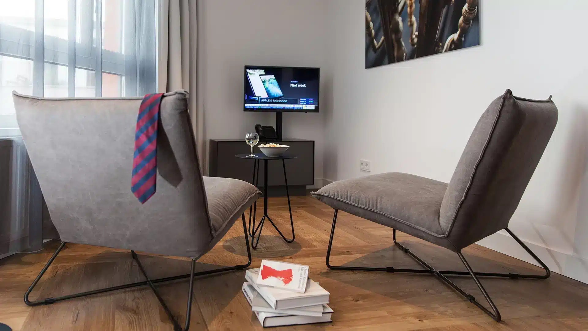 Zwei graue Sessel mit TV in einem Apartment